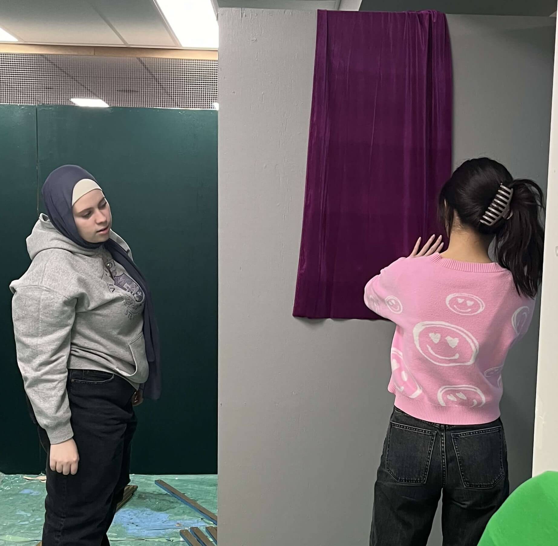 Two team members positioning the banner on the kiosk.