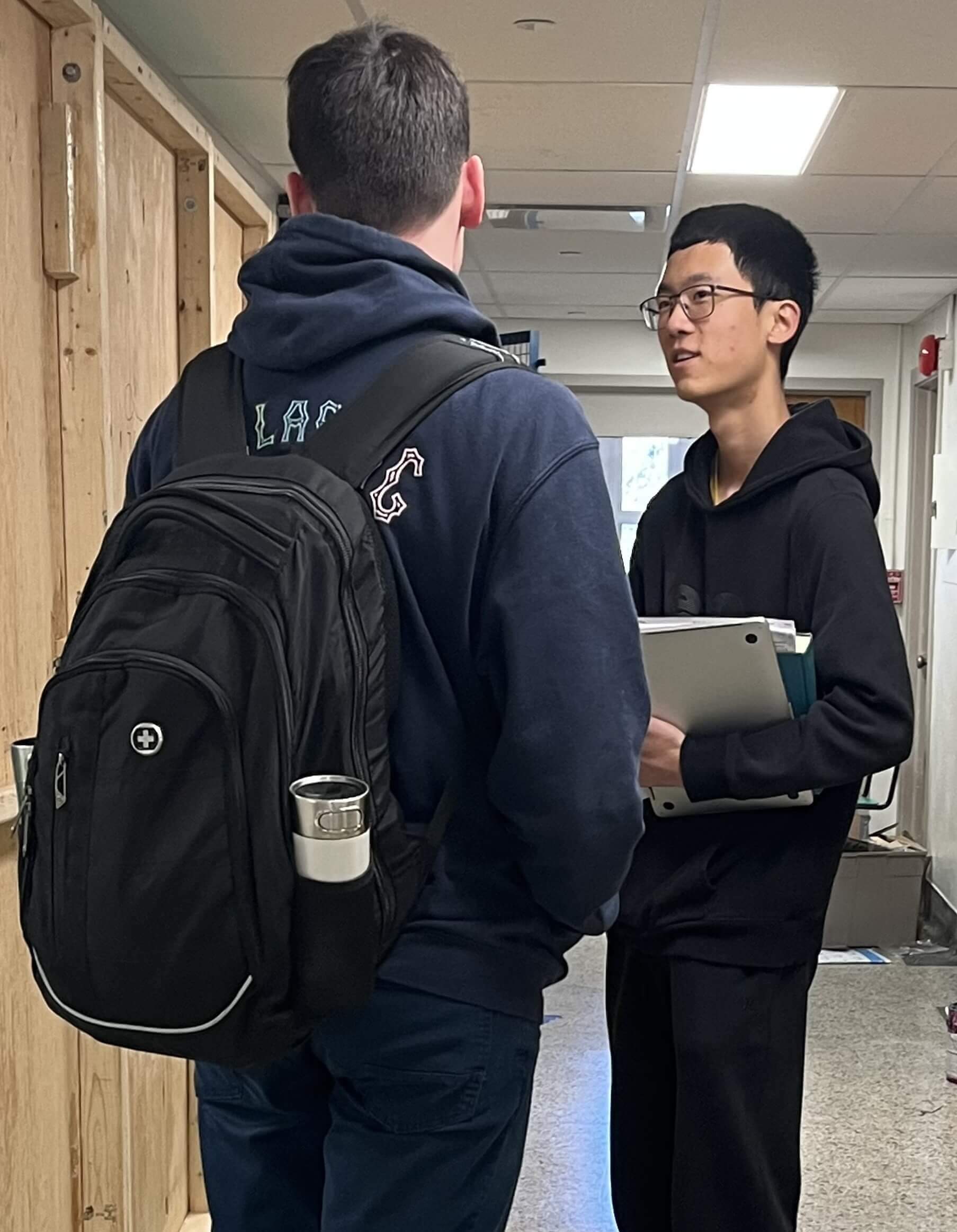 Deux membres de l'équipe discutant dans un couloir.