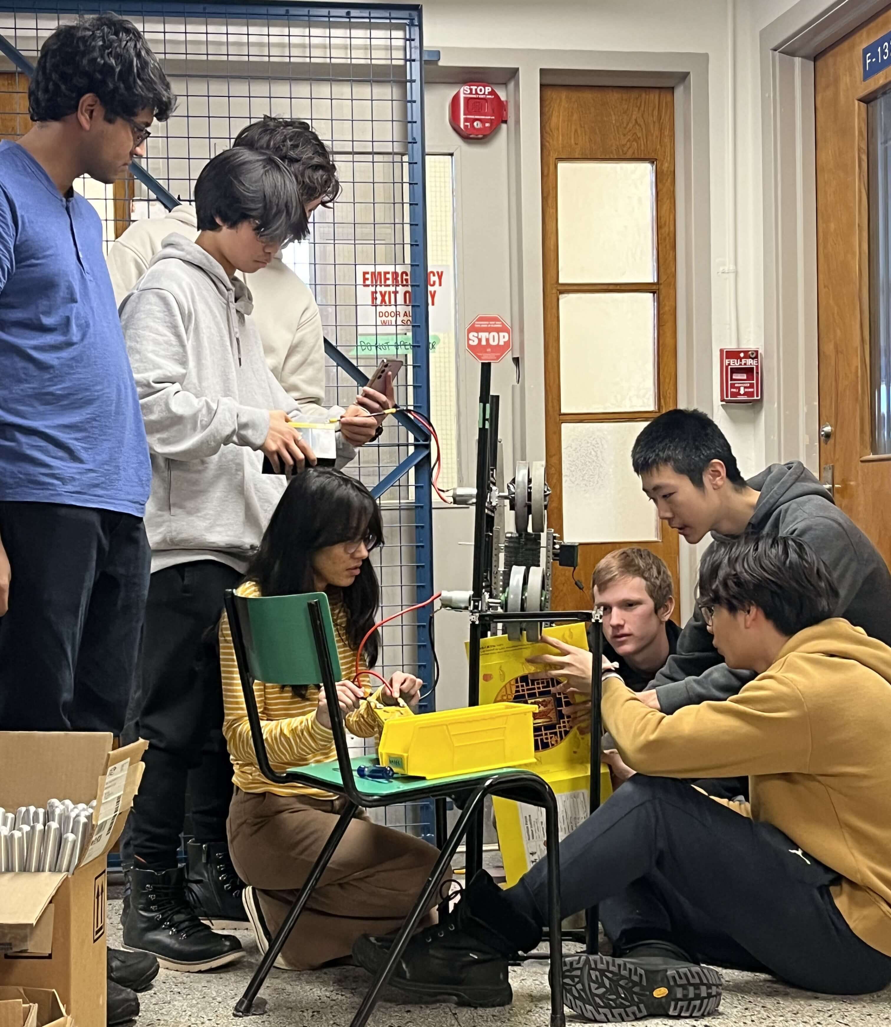 7 membres de l'équipe robot en train de tester le mécanisme de lancement à double volant d'inertie.