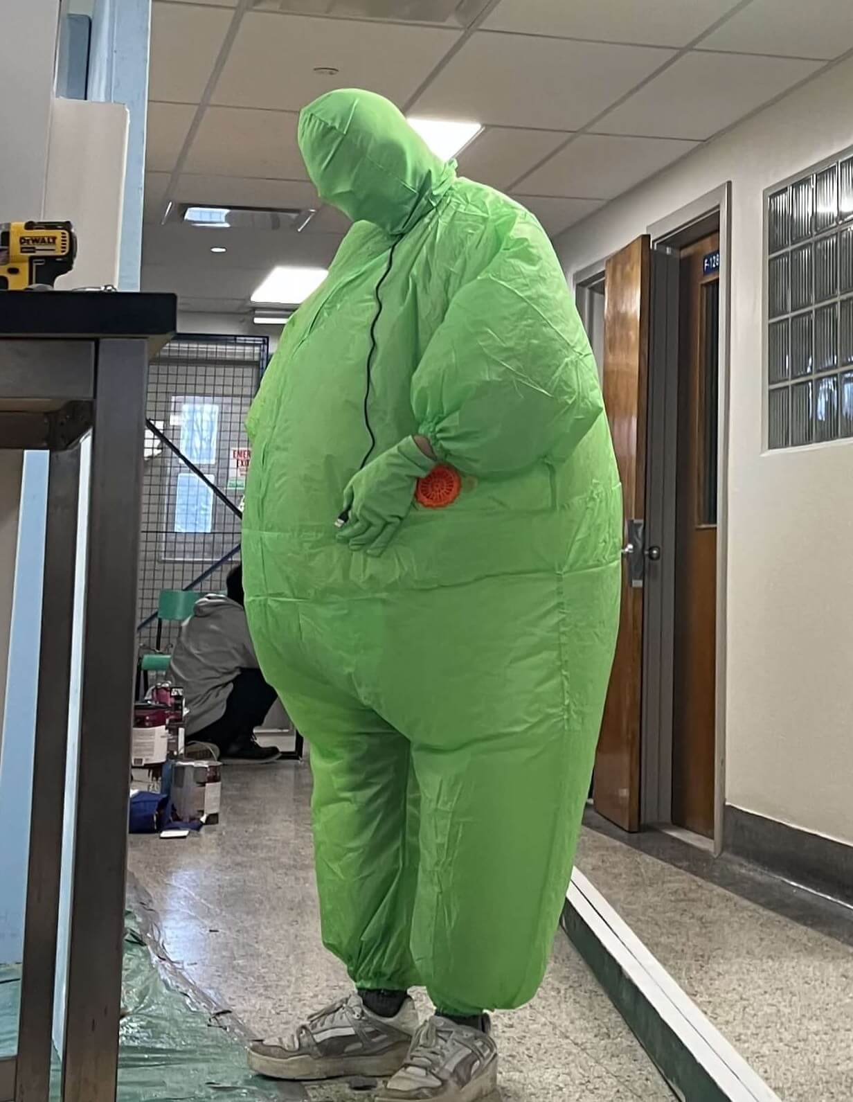 Un membre de l'équipe en costume de cochon vert.